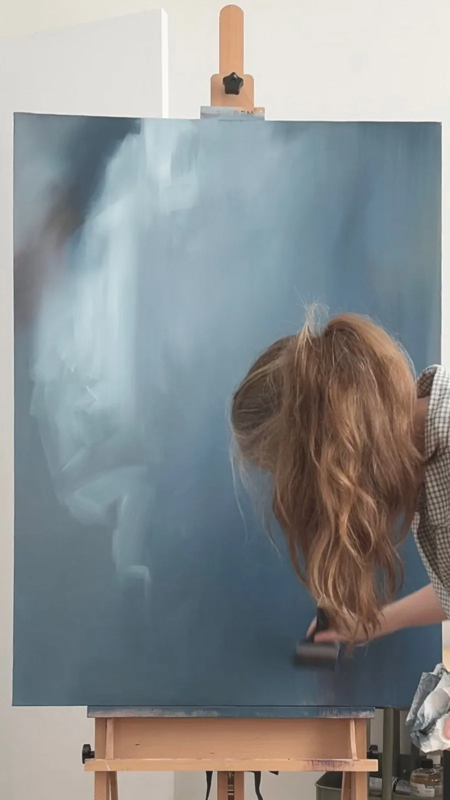 Shelley at the easel, working on a blue painting